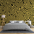 Modern living room featuring Black and Gold Geometric Maze wallpaper creating a stunning accent wall behind grey sofa