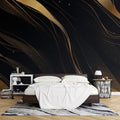 Modern black and gold abstract wallpaper creating a stunning focal point in a minimalist living room with tall windows