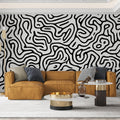 Black and white abstract pattern wallpaper creating dramatic impact in a modern minimalist living room setting