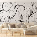 Black spiral floral wallpaper mural creating dramatic impact in a modern living room with white furniture