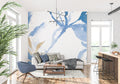 Blue and gold abstract wallpaper creating movement in a modern living room with white furniture