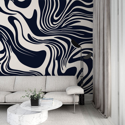 Navy and cream abstract wave wallpaper creating movement in a modern living room with gray sofa and natural light