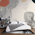 Abstract line art wallpaper creating a modern focal point in a minimalist living room with terracotta and cream accents