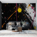 Abstract paint splash wallpaper creating dramatic impact in modern living room with black sofa and minimal decor