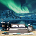 Northern lights wallpaper creates a magical atmosphere in a modern bedroom, green aurora dancing above mountains