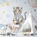 Baby tiger wallpaper in a bright nursery with white furniture, showing the watercolor design's soft glow