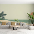 Beach mural wallpaper styled in modern living room showing minimalist coastal scene with gentle palm trees and sage tones