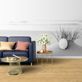 Black and white beach scene wallpaper creating a calm atmosphere in a modern living room with minimal furniture