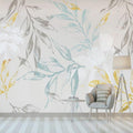 Botanical leaf wallpaper with blue and gold tones creating a calm atmosphere in a modern living room