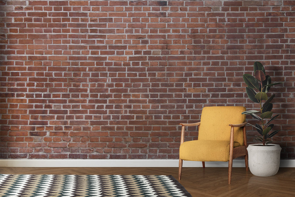 Red brick wallpaper creating an industrial accent wall in a modern living room with minimal furniture