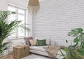 White brick mural wallpaper in modern living room with gray sofa and plants