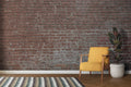 3D Brick Wallpaper creating industrial charm in modern living room with grey sofa and metal accents