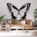 Black and white butterfly wallpaper mural creating drama in a modern living room with minimal furniture