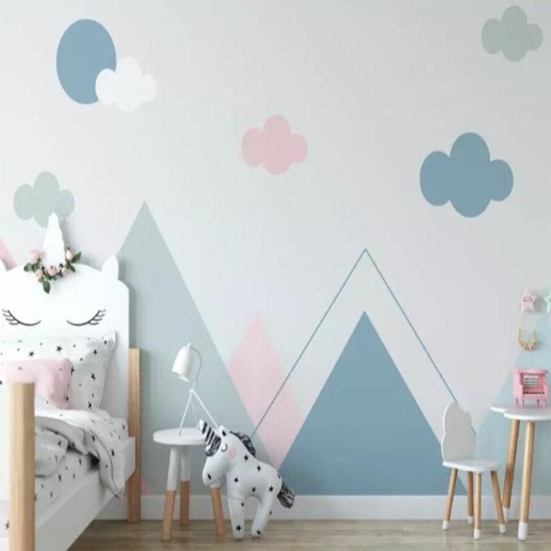 Cloud nursery wallpaper with pastel mountains creating a peaceful atmosphere in a modern white nursery with wooden furniture