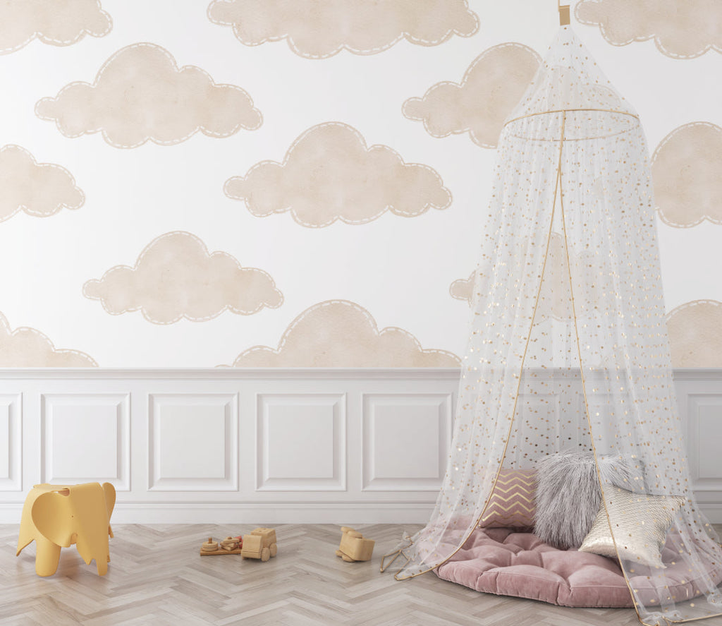 Beige cloud wallpaper in a toddler's reading nook with comfy chair