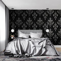 Black and silver damask wallpaper in modern living room with grey sofa and crystal chandelier
