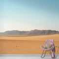 Desert landscape wallpaper creating a calm atmosphere in a modern living room with minimal furniture