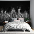 Black and white wheat field wallpaper creating dramatic impact in a modern dining room with minimal furniture