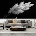 Black and white pampas grass wallpaper creating dramatic contrast in a modern living room with minimalist furniture