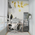 Black and gold watercolor leaf mural in modern living room with grey sofa