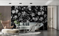 Black and white floral wallpaper adding drama to a modern living room with grey sofa and natural light