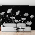 Black and white poppy wallpaper mural creating dramatic impact in a modern living room with minimal furniture
