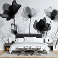 Black and white floral wallpaper mural creating drama in a modern living room with high ceilings and minimal furniture
