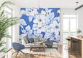 Large white floral wallpaper creating a stunning focal point in a modern living room with blue accents
