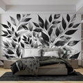 Black and white botanical wallpaper creating depth in a minimal Scandinavian living room with natural light