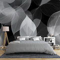 Black and white botanical wallpaper creating a dramatic statement wall in a modern living room with minimalist furniture