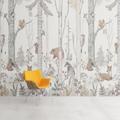 Forest animals wallpaper creating a cozy atmosphere in a bright nursery with white furniture and pink accents