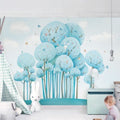 Blue forest wallpaper with butterflies creating a magical atmosphere in a modern nursery with white furniture