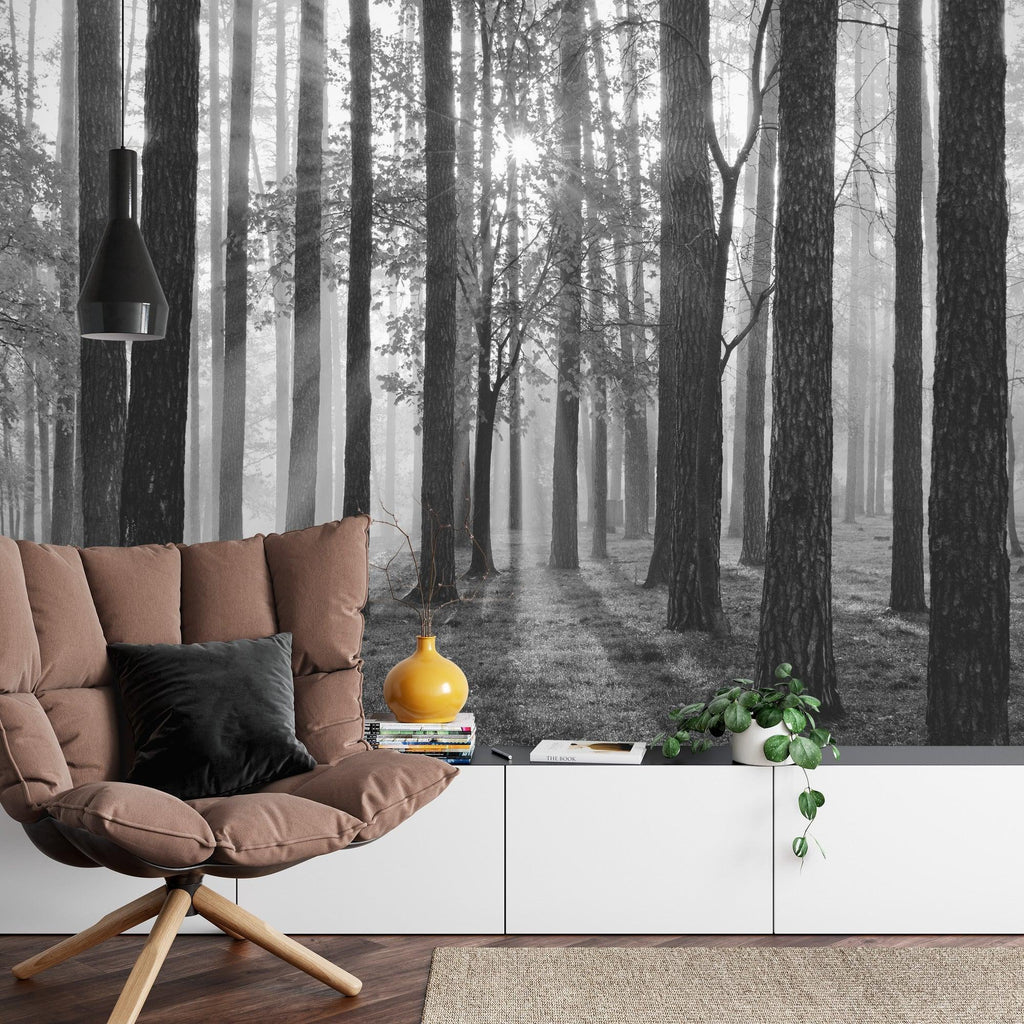 Black and white forest mural wallpaper creating depth in modern living room with minimal furniture