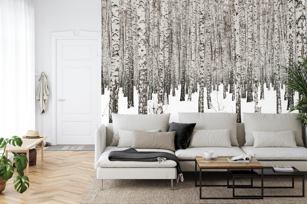 Winter forest wallpaper creating a calm atmosphere in a modern Scandinavian living room with white furniture