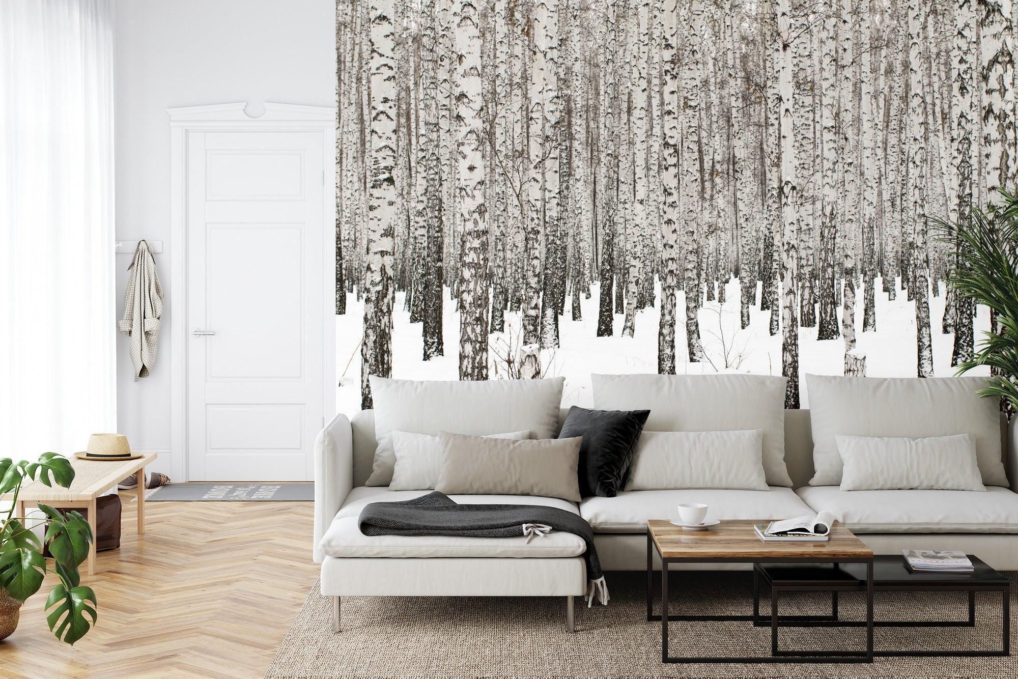 Winter forest wallpaper creating a calm atmosphere in a modern Scandinavian living room with white furniture