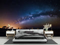 Galaxy wallpaper mural bringing cosmic wonder to a modern bedroom with soft lighting