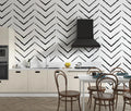 Modern black and white geometric wallpaper creating depth in a minimalist living room setting