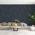 Modern geometric wallpaper with lines and dots pattern shown in a minimalist living room setting with grey sofa