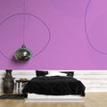 Modern purple geometric wallpaper mural creating depth in a minimalist living room with grey furniture