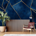 Geometric navy and gold wallpaper in modern living room setting with clean furniture and natural light