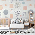 Geometric nursery wallpaper with pastel shapes brightening a modern baby room with white furniture