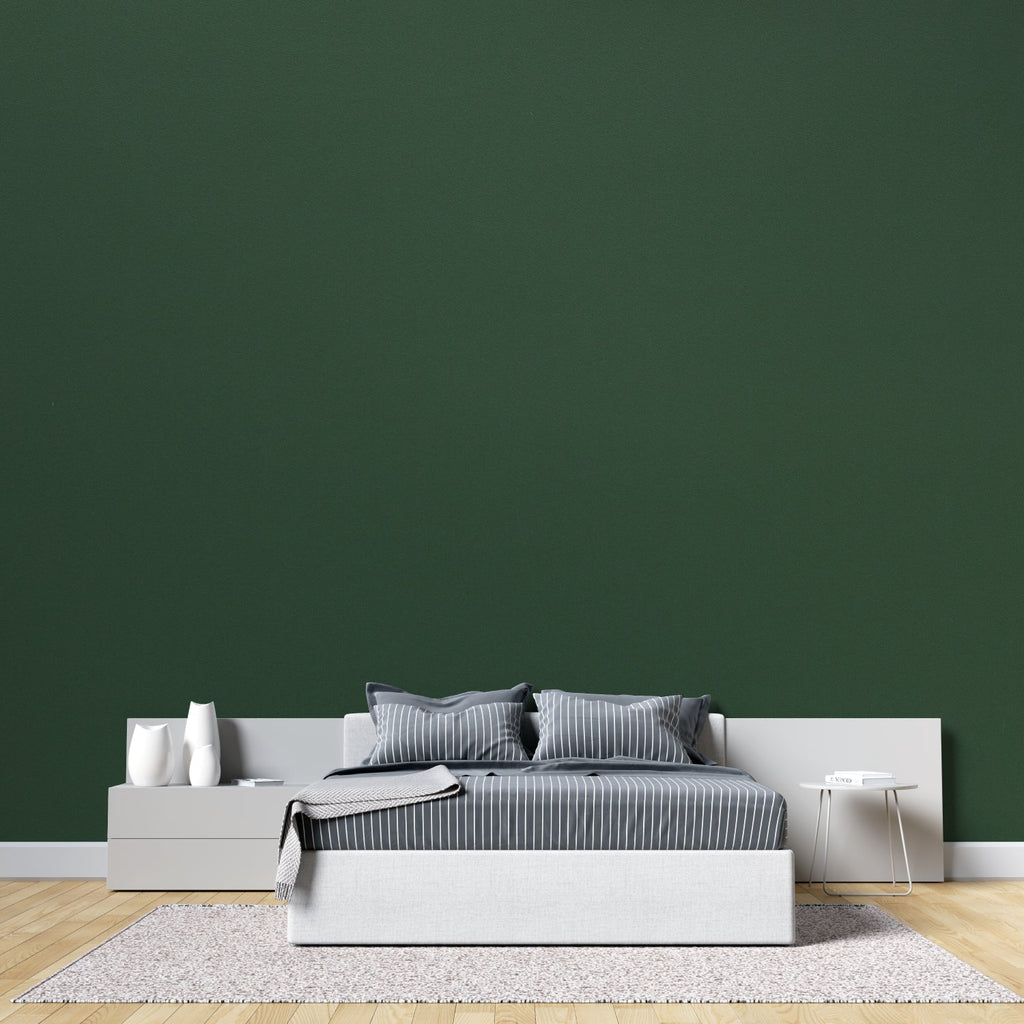 Deep green wall mural adding depth to a minimalist dining room setting