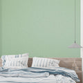 Sage green minimalist wallpaper in modern living room showing textured surface catching natural light