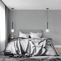 Modern grey wallpaper mural in a minimalist living room with natural light highlighting its subtle texture