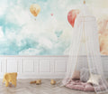Hot air balloon wallpaper creating a dreamy atmosphere in a bright nursery with white furniture
