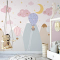 Pink hot air balloon nursery wallpaper creating a magical atmosphere in a modern baby room with white furniture