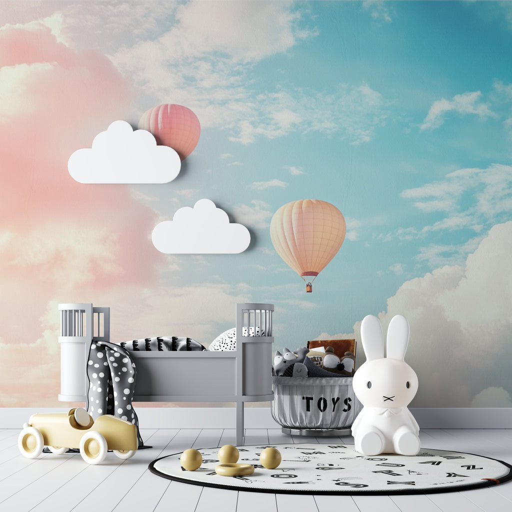 Hot air balloon wallpaper in a bright nursery with white furniture and pink accents