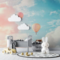 Hot air balloon wallpaper in a bright nursery with white furniture and pink accents