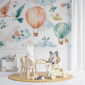 Hot air balloon nursery wallpaper creating a magical atmosphere in a cozy white nursery with rocking chair