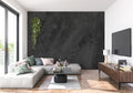Black concrete effect wallpaper in modern living room creates industrial atmosphere with dark furniture